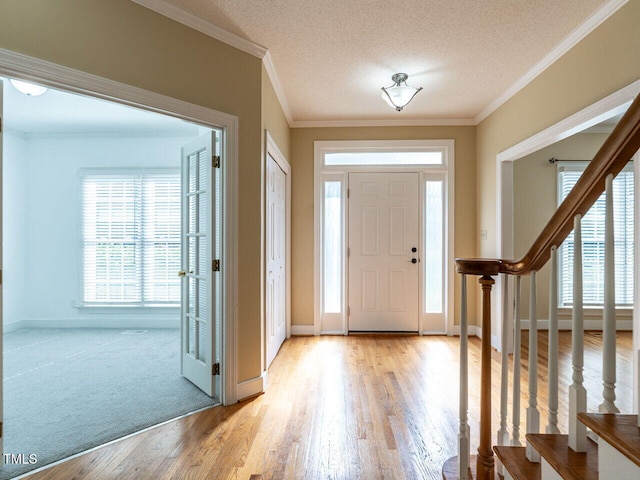 103 Glenstone Ln, Cary, NC 27518 - entrance foyer with light wood finished floors, stairway, a textured ceiling, and ornamental molding