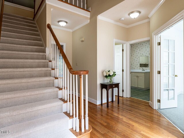 103 Glenstone Ln, Cary, NC 27518 - stairs featuring crown molding and wood finished floors