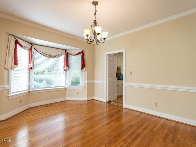 103 Glenstone Ln, Cary, NC 27518 - empty room with a chandelier, light wood-style floors, and crown molding