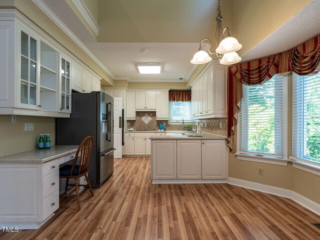 103 Glenstone Ln, Cary, NC 27518 - kitchen with light wood-style flooring, fridge with ice dispenser, healthy amount of natural light, ornamental molding, and backsplash