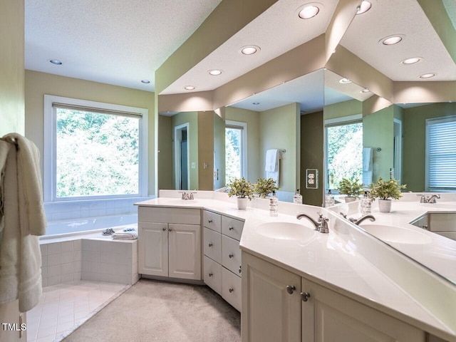 103 Glenstone Ln, Cary, NC 27518 - bathroom with double vanity, a garden tub, recessed lighting, and a textured ceiling