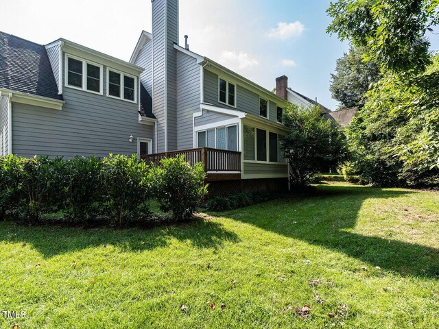 103 Glenstone Ln, Cary, NC 27518 - back of house featuring a chimney, a yard, a wooden deck, and roof with shingles