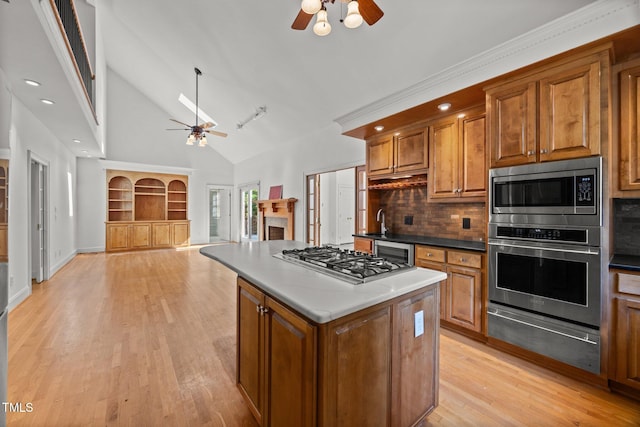3604 Eden Croft Dr, Raleigh, NC 27612 - kitchen with a ceiling fan, brown cabinets, high vaulted ceiling, a warming drawer, and appliances with stainless steel finishes