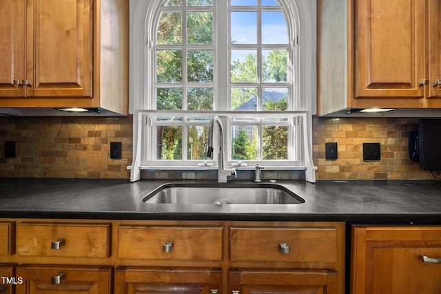 3604 Eden Croft Dr, Raleigh, NC 27612 - kitchen with brown cabinets, dark countertops, and decorative backsplash