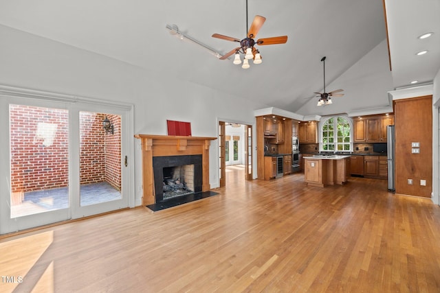 3604 Eden Croft Dr, Raleigh, NC 27612 - unfurnished living room with a ceiling fan, light wood finished floors, high vaulted ceiling, a fireplace, and beverage cooler