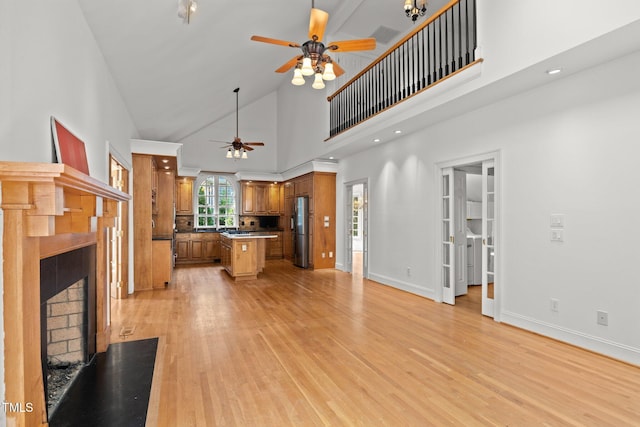 3604 Eden Croft Dr, Raleigh, NC 27612 - unfurnished living room with a ceiling fan, a fireplace with flush hearth, light wood-style floors, and high vaulted ceiling
