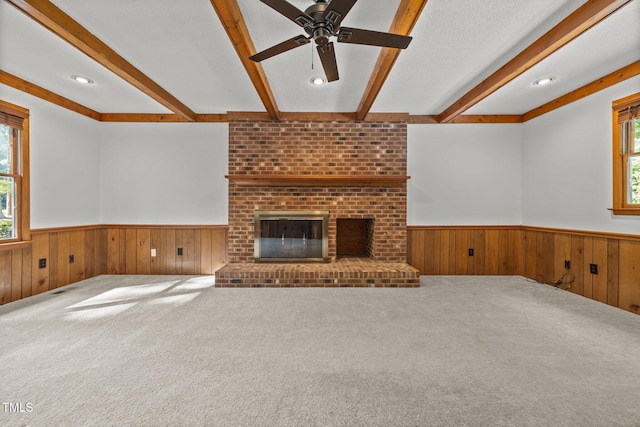 12501 Hardee Rd, Raleigh, NC 27614 - unfurnished living room with wainscoting, beam ceiling, wooden walls, a ceiling fan, and carpet