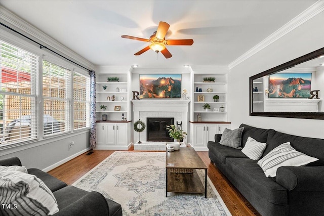 102 Barometer Ln, Cary, NC 27513 - living area featuring a ceiling fan, wood finished floors, a fireplace, crown molding, and built in shelves