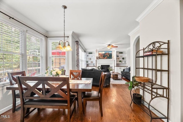 102 Barometer Ln, Cary, NC 27513 - dining area featuring a fireplace, ornamental molding, ceiling fan, wood finished floors, and built in shelves
