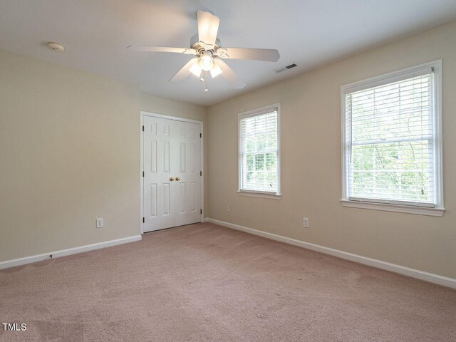 4032 Brook Cross Dr, Apex, NC 27539 - unfurnished bedroom featuring light colored carpet, ceiling fan, and a closet