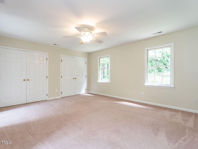 4032 Brook Cross Dr, Apex, NC 27539 - unfurnished bedroom with two closets, light carpet, and a ceiling fan