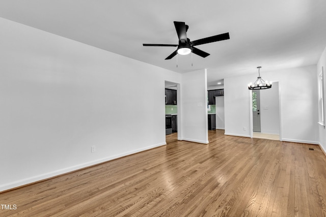 2408 Glascock St, Raleigh, NC 27610 - empty room featuring a chandelier, a ceiling fan, and light wood-type flooring