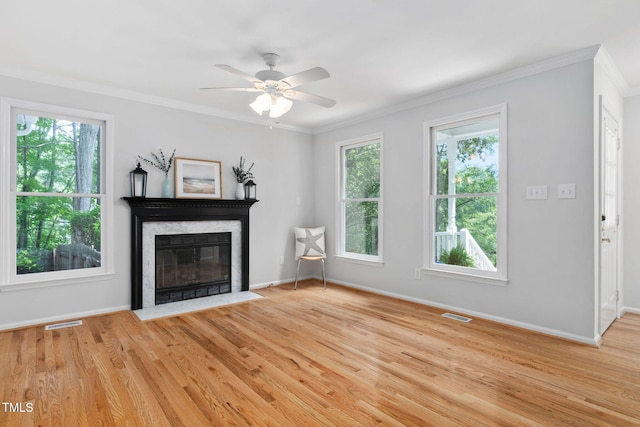 114 Dalmeny Dr, Cary, NC 27513 - unfurnished living room featuring healthy amount of natural light, crown molding, a premium fireplace, and light wood-style floors