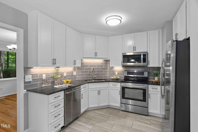 114 Dalmeny Dr, Cary, NC 27513 - kitchen featuring stainless steel appliances, white cabinetry, decorative backsplash, and dark stone counters