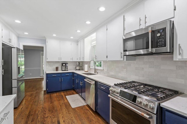 1920 Quail Ridge Rd, Raleigh, NC 27609 - kitchen featuring stainless steel appliances, blue cabinets, white cabinetry, ornamental molding, and dark wood-style flooring