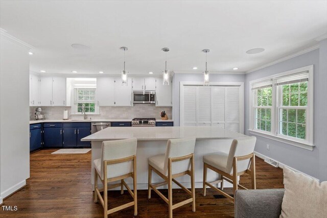 1920 Quail Ridge Rd, Raleigh, NC 27609 - kitchen featuring blue cabinetry, appliances with stainless steel finishes, decorative backsplash, ornamental molding, and light countertops