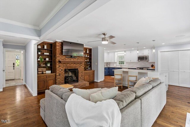 1920 Quail Ridge Rd, Raleigh, NC 27609 - living room with a fireplace, dark wood-style flooring, crown molding, ceiling fan, and recessed lighting