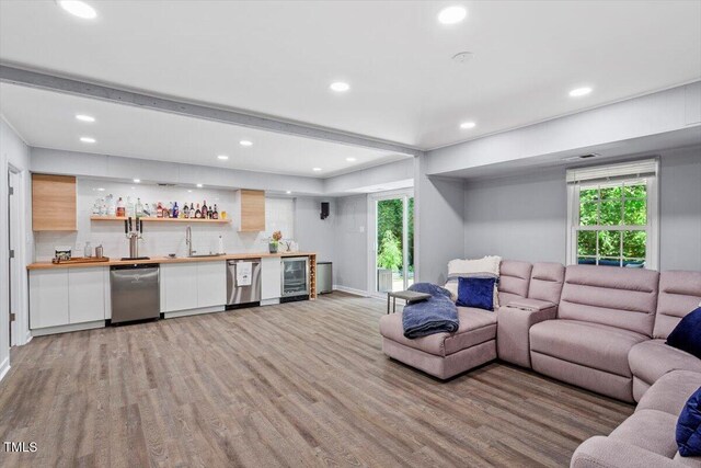 1920 Quail Ridge Rd, Raleigh, NC 27609 - living room with wine cooler, bar with sink, light wood-style flooring, recessed lighting, and healthy amount of natural light