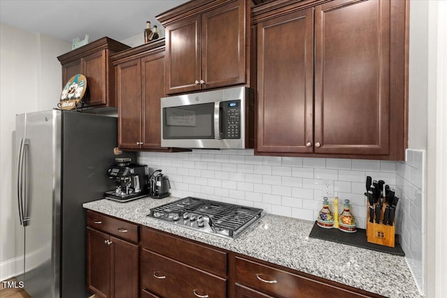 2981 Thurman Dairy, Wake Forest, NC 27587 - kitchen featuring appliances with stainless steel finishes, backsplash, light stone countertops, and dark brown cabinets