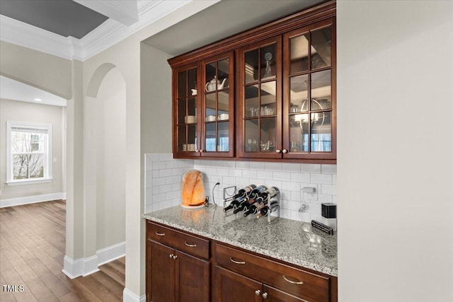 2981 Thurman Dairy, Wake Forest, NC 27587 - bar featuring crown molding, decorative backsplash, arched walkways, and dark wood-style floors