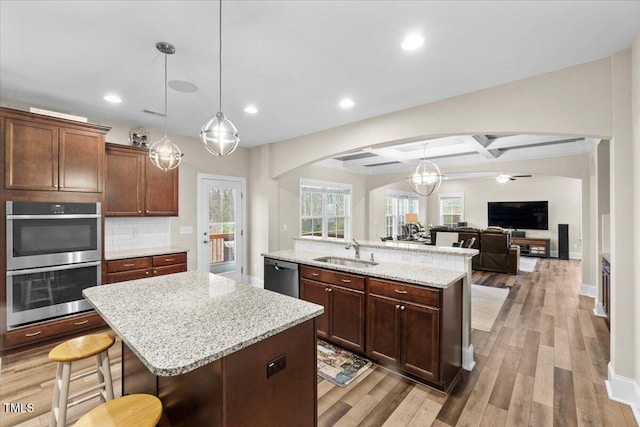 2981 Thurman Dairy, Wake Forest, NC 27587 - kitchen with a center island with sink, arched walkways, stainless steel appliances, light wood-style flooring, and recessed lighting