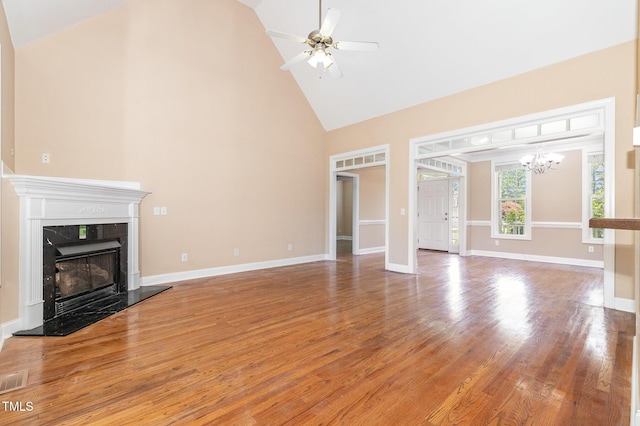 145 Adams Pointe Ct, Angier, NC 27501 - unfurnished living room with high vaulted ceiling, a high end fireplace, light wood finished floors, a ceiling fan, and a chandelier