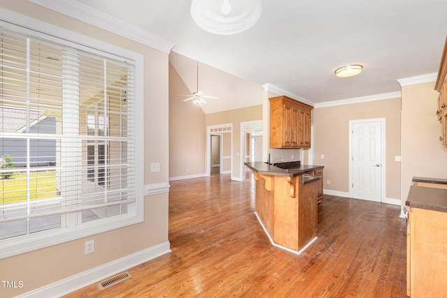 145 Adams Pointe Ct, Angier, NC 27501 - kitchen featuring a kitchen breakfast bar, a ceiling fan, a peninsula, dark countertops, and crown molding