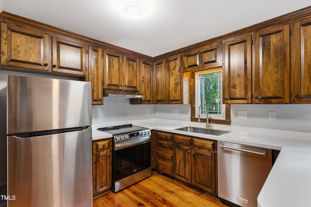 109 Grey Fox Ct, Cary, NC 27511 - kitchen with stainless steel appliances, light countertops, light wood-type flooring, and under cabinet range hood