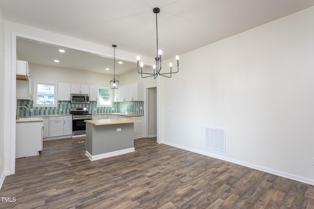 112 N Sellers St, Selma, NC 27576 - kitchen with stainless steel appliances, dark wood finished floors, backsplash, recessed lighting, and white cabinetry