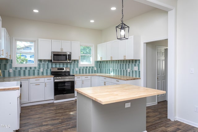 112 N Sellers St, Selma, NC 27576 - kitchen featuring stainless steel appliances, wooden counters, dark wood-style floors, pendant lighting, and white cabinets