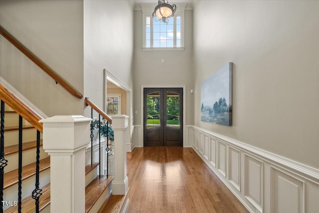 3728 Westbury Lake Dr, Raleigh, NC 27603 - foyer entrance featuring plenty of natural light, light wood-style flooring, stairway, a wainscoted wall, and french doors