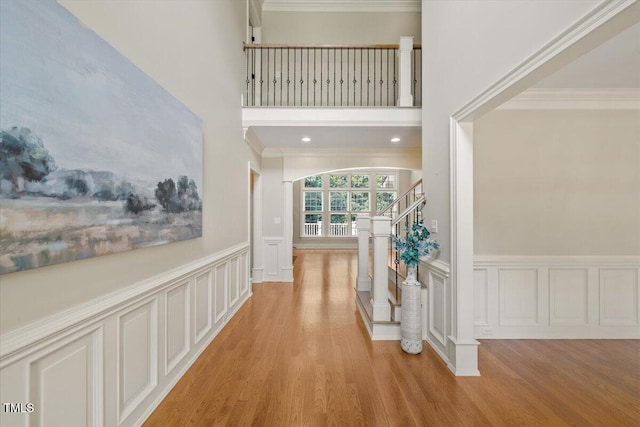 3728 Westbury Lake Dr, Raleigh, NC 27603 - hallway with a decorative wall, light wood-style flooring, crown molding, stairway, and a wainscoted wall
