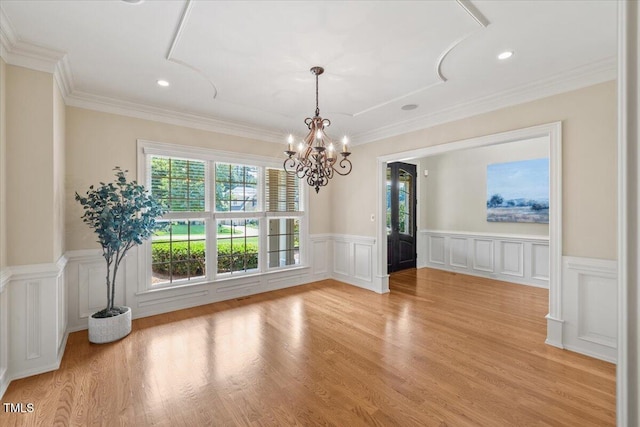 3728 Westbury Lake Dr, Raleigh, NC 27603 - unfurnished dining area with a chandelier, wainscoting, a decorative wall, light wood-style flooring, and crown molding
