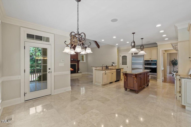 3728 Westbury Lake Dr, Raleigh, NC 27603 - kitchen with appliances with stainless steel finishes, crown molding, cream cabinetry, an island with sink, and a warm lit fireplace