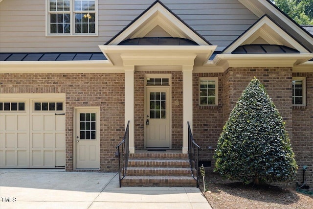 3728 Westbury Lake Dr, Raleigh, NC 27603 - property entrance with a garage, brick siding, a standing seam roof, and a metal roof