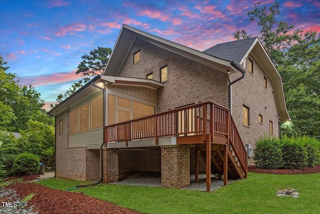 1103 Roosevelt Dr, Chapel Hill, NC 27514 - back of property at dusk featuring a lawn, a wooden deck, brick siding, and stairway