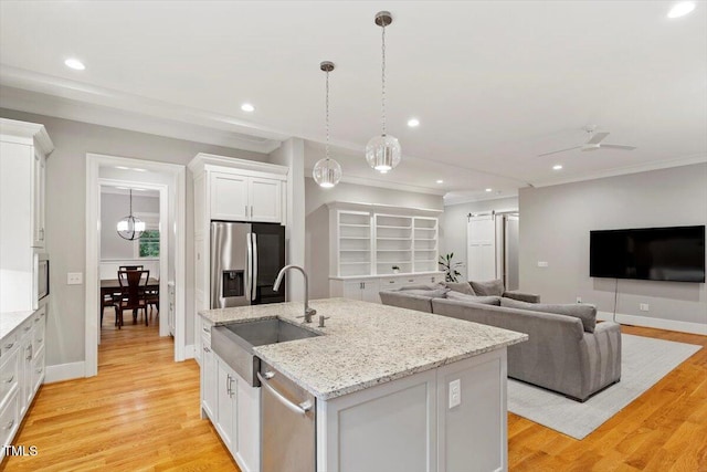 1103 Roosevelt Dr, Chapel Hill, NC 27514 - kitchen with stainless steel appliances, white cabinets, open floor plan, an island with sink, and light wood-style flooring