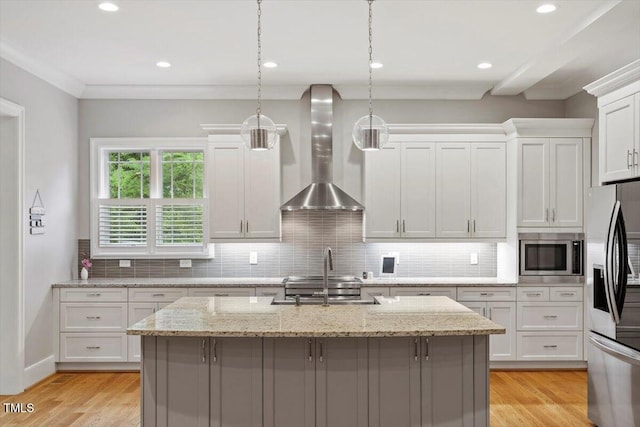 1103 Roosevelt Dr, Chapel Hill, NC 27514 - kitchen featuring wall chimney range hood, appliances with stainless steel finishes, a center island with sink, white cabinets, and tasteful backsplash
