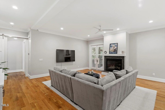 1103 Roosevelt Dr, Chapel Hill, NC 27514 - living room with crown molding, a ceiling fan, recessed lighting, a glass covered fireplace, and light wood finished floors