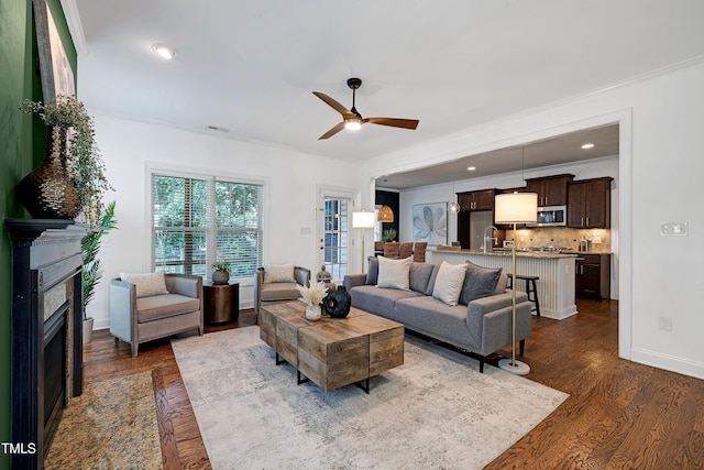 837 Varina Ln, Fuquay Varina, NC 27526 - living room with dark wood finished floors, ceiling fan, a fireplace, and crown molding