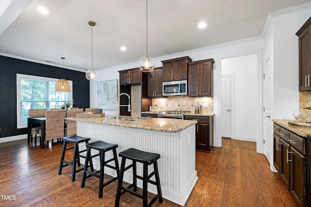 837 Varina Ln, Fuquay Varina, NC 27526 - kitchen with appliances with stainless steel finishes, dark wood-style floors, tasteful backsplash, dark brown cabinetry, and light stone countertops