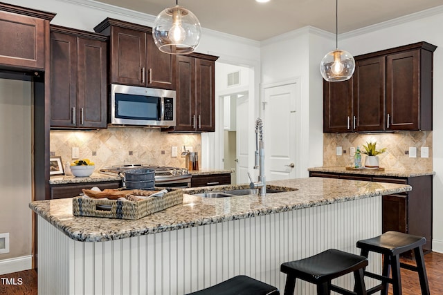837 Varina Ln, Fuquay Varina, NC 27526 - kitchen featuring appliances with stainless steel finishes, dark brown cabinets, a breakfast bar, dark wood-style floors, and crown molding
