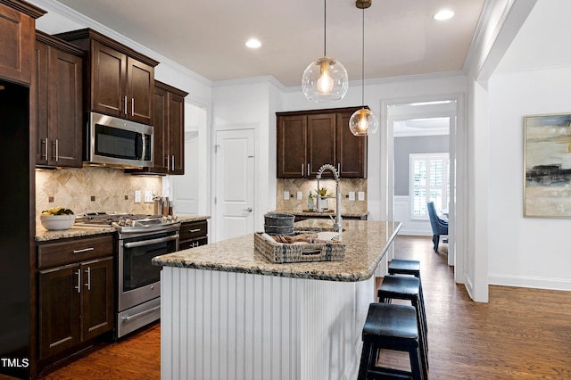 837 Varina Ln, Fuquay Varina, NC 27526 - kitchen with stainless steel appliances, dark brown cabinets, dark wood-type flooring, light stone countertops, and recessed lighting