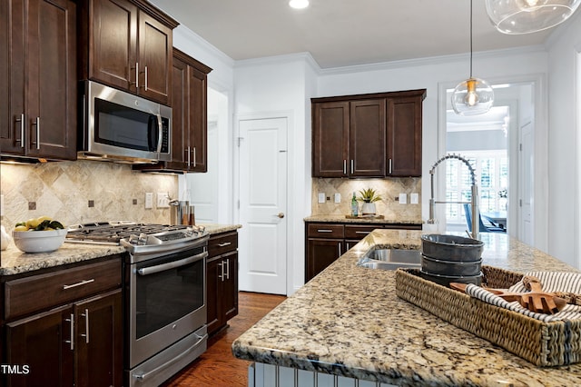 837 Varina Ln, Fuquay Varina, NC 27526 - kitchen featuring appliances with stainless steel finishes, dark wood-style flooring, dark brown cabinets, light stone countertops, and ornamental molding