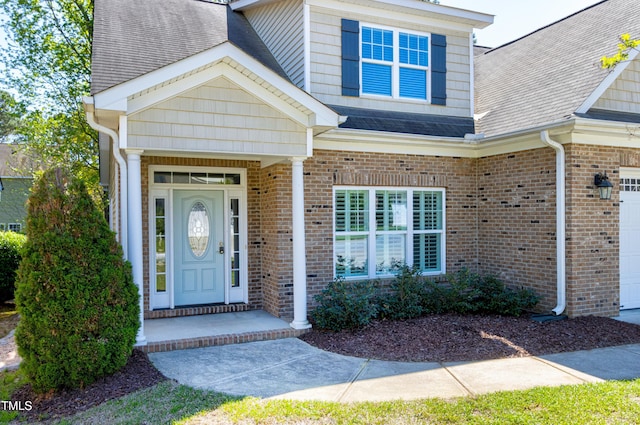 837 Varina Ln, Fuquay Varina, NC 27526 - view of exterior entry featuring a garage, a shingled roof, and brick siding
