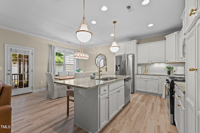 1831 Grandmaster Way, Wake Forest, NC 27587 - kitchen with stainless steel appliances, white cabinetry, light wood finished floors, crown molding, and recessed lighting