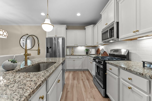 1831 Grandmaster Way, Wake Forest, NC 27587 - kitchen featuring appliances with stainless steel finishes, white cabinetry, ornamental molding, light wood finished floors, and tasteful backsplash