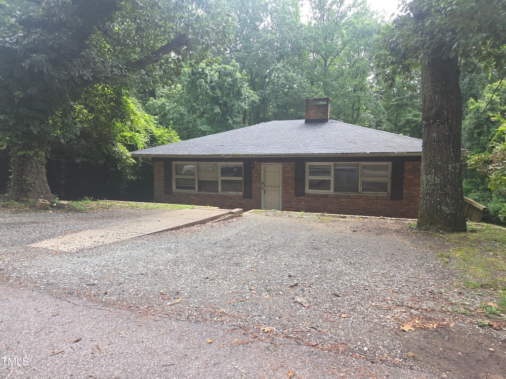 1812 Birmingham Ave, Durham, NC 27704 - ranch-style house with a chimney, brick siding, and driveway