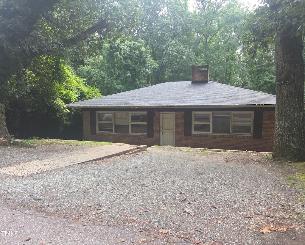 1812 Birmingham Ave, Durham, NC 27704 - view of front of home featuring brick siding, a chimney, and gravel driveway