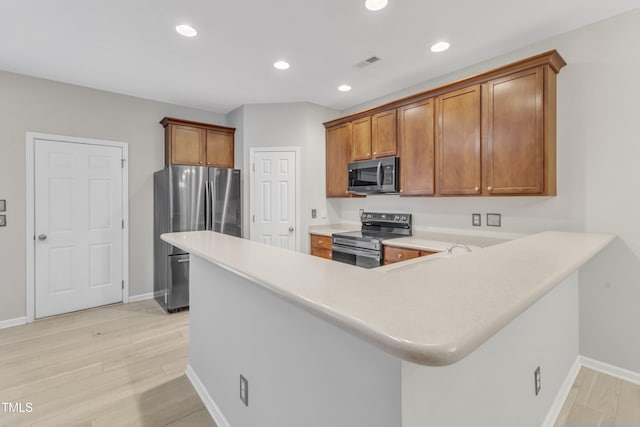 3634 Olympia Dr, Raleigh, NC 27603 - kitchen with appliances with stainless steel finishes, brown cabinets, light countertops, light wood-style floors, and recessed lighting